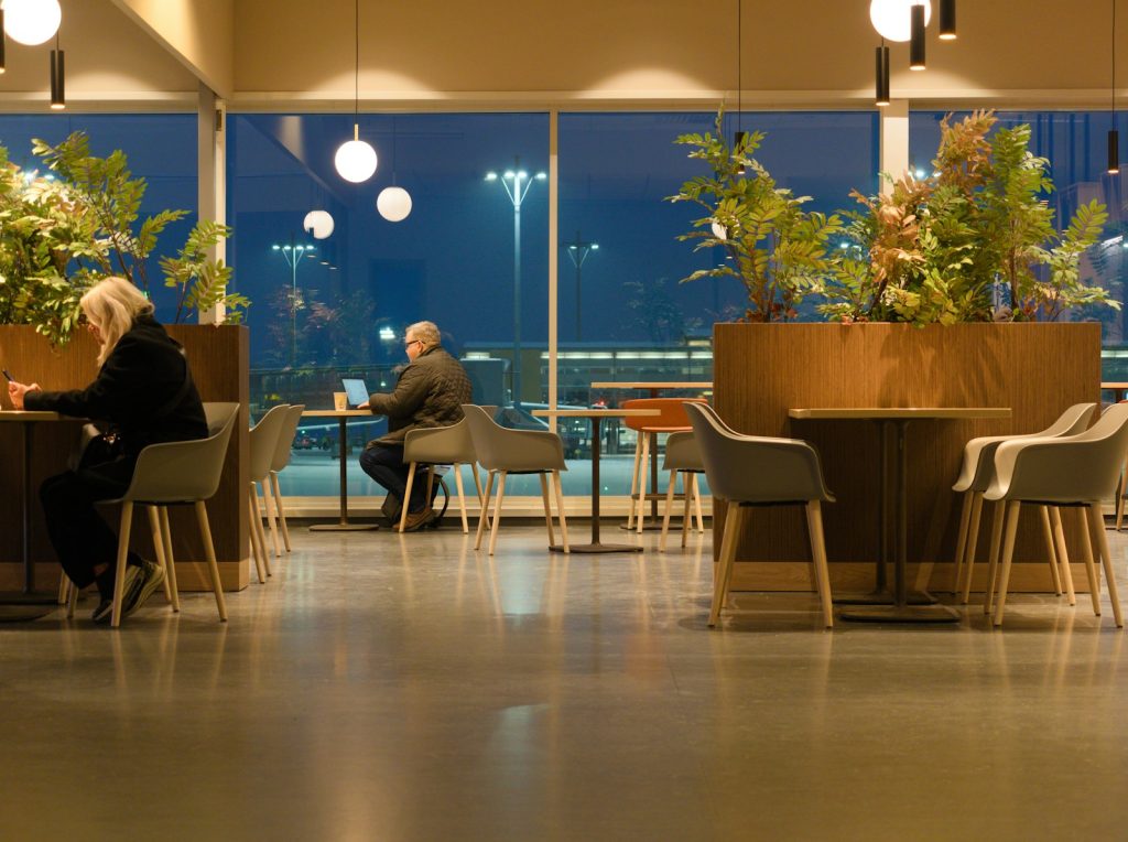 Two people sitting in a modern cafe at dusk