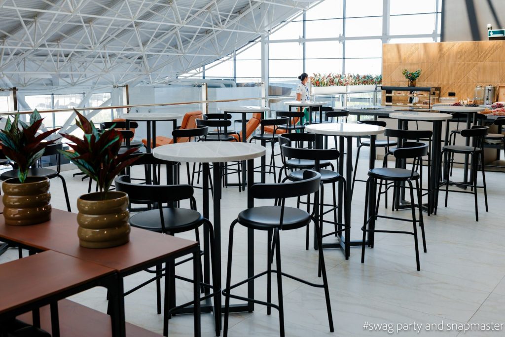 Empty modern cafe interior with high tables and large windows