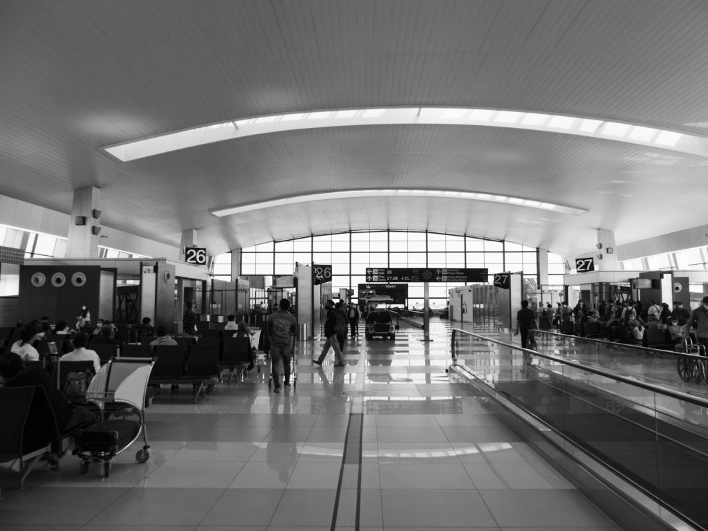 a black and white photo of people walking through an airport
