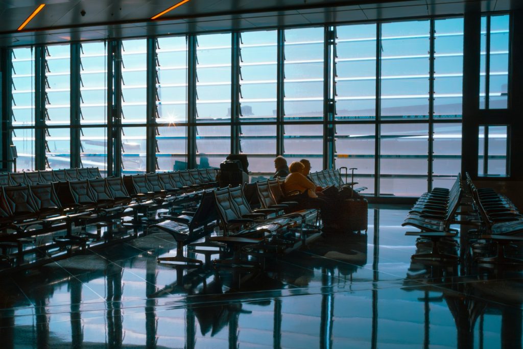 An airport waiting area with large windows and reflections